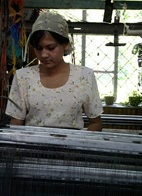 Mary E. Frederickson, Tending an early twentieth century Draper loom made in Massachusetts for use in mills across the Carolinas, Georgia, and Alabama, Margilan, Uzbekistan, 2006. Mary E. Frederickson, Tending an early twentieth century Draper loom made in Massachusetts for use in mills across the Carolinas, Georgia, and Alabama, Margilan, Uzbekistan, 2006.