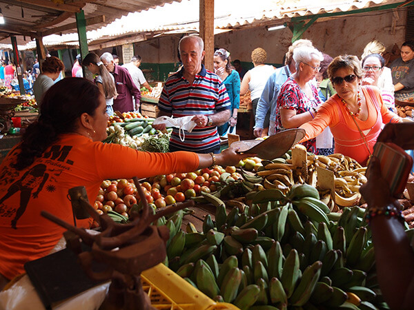 Charles D. Thompson, Jr., Osiris Cueto weighs produce for her customer at the Mercado Agropecuario Beleu. Old Havana, Cuba, December 2010.  Charles D. Thompson, Jr., Osiris Cueto weighs produce for her customer at the Mercado Agropecuario Beleu. Old Havana, Cuba, December 2010.