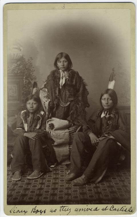 Sioux boys as they arrived at Carlisle, Pennsylvania, ca. 1892. Photograph by unknown creator. Courtesy of New York Public Library Art and Picture Collection Division, digitalcollections.nypl.org/items/510d47e1-1b90-a3d9-e040-e00a18064a99.