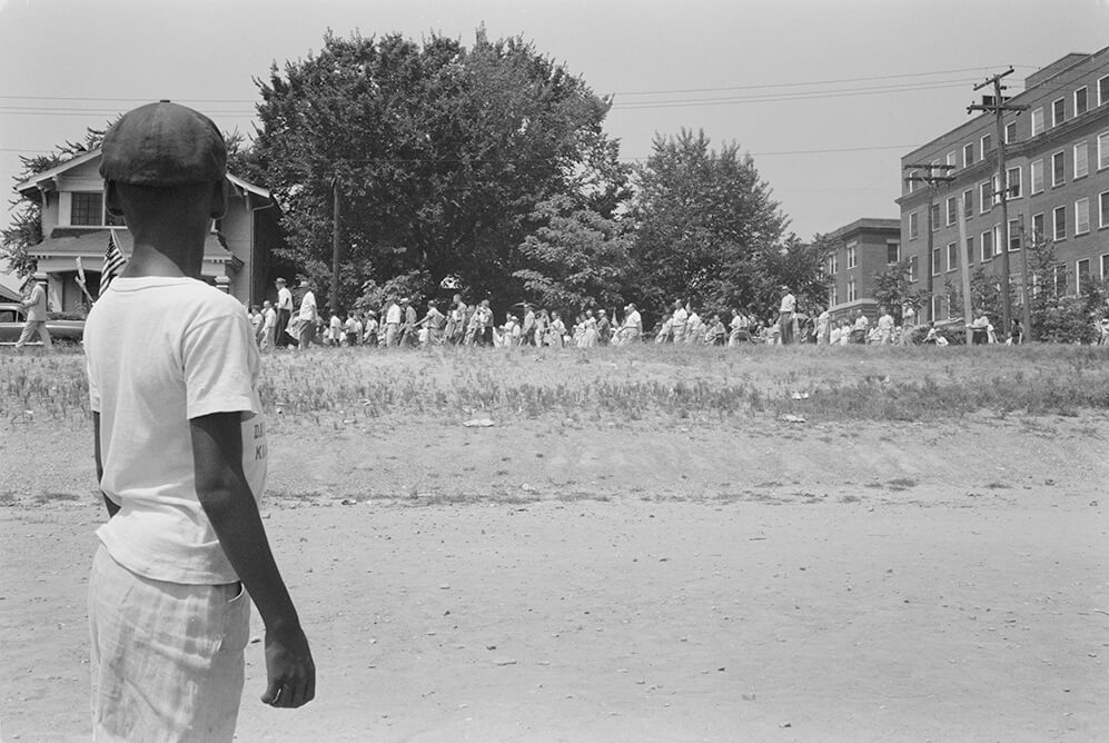 Child watching a march protesting the admission of "Little Rock Nine" to Central High School, Little Rock, Arkansas, August 20, 1959. Photograph by John T. Bledsoe. Courtesy of the Library of Congress Prints and Photographs Division, loc.gov/item/2003654358.