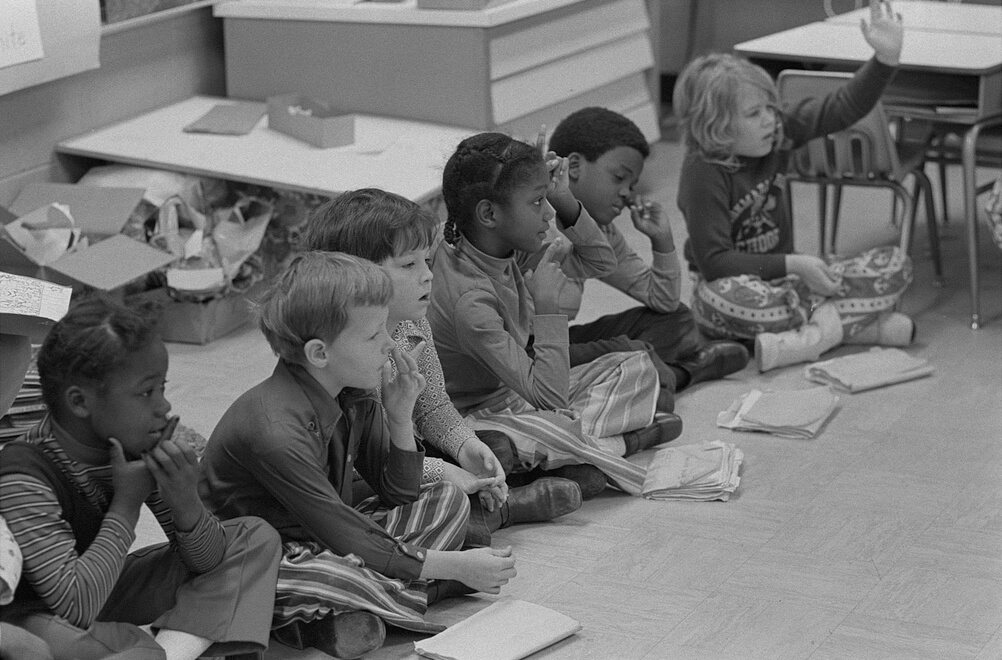 First grade class of African American and white school children seated on the floor at Albemarle Road Elementary School, Charlotte, North Carolina, February 21, 1973. Photograph by Warren K. Leffler. Courtesy of the Library of Congress Prints and Photographs Division, loc.gov/item/2011646494.