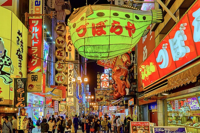 Osaka Nightlife, Osaka, Japan, October 23, 2016. Photograph by Flickr user Pedro Szekely. Creative Commons license CC-BY-SA 2.0. Photograph of a busy street in Osaka, Japan, filled with people, colorful paper lanterns, and glowing signs.