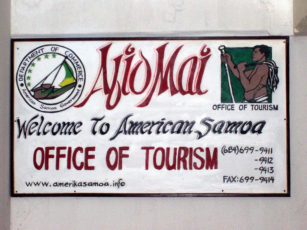 A photograph of a hand painted sign for the American Samoa office of tourism.