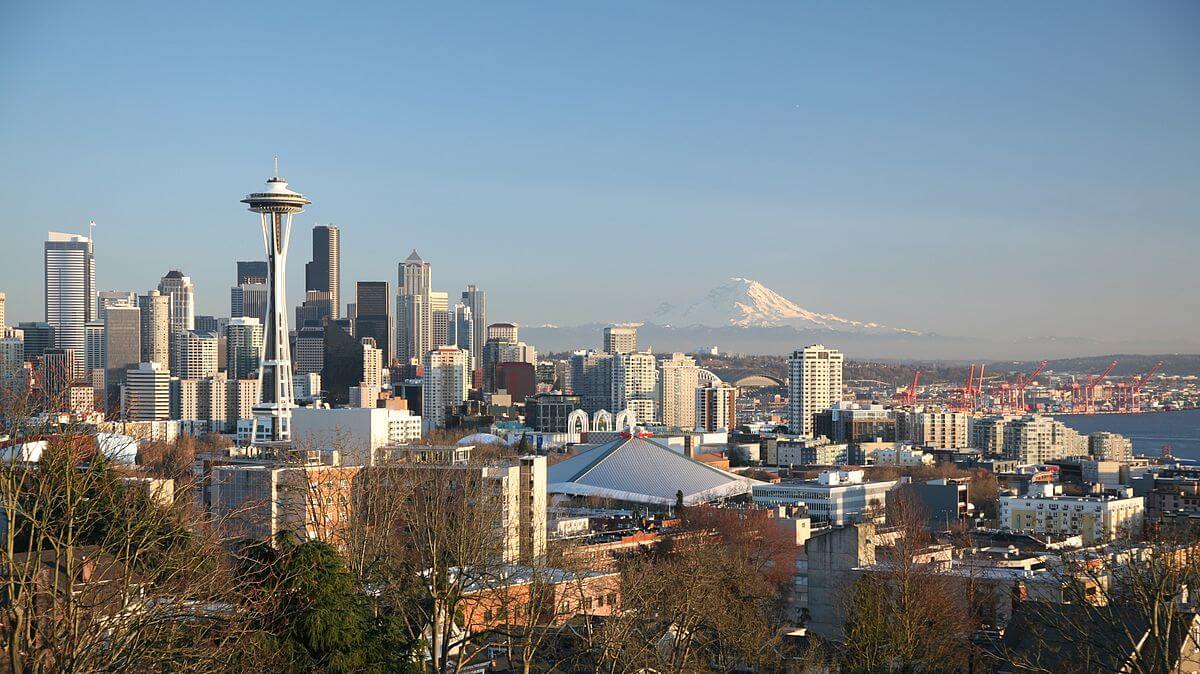 Seattle Skyline view from Queen Anne Hill, Seattle, Washington, February 17, 2010. Photograph by Wikimedia Commons user Daniel Schwen. Creative Commons license CC BY-SA 4.0. Photograph of the Seattle skyline on a sunny, cloudless day.