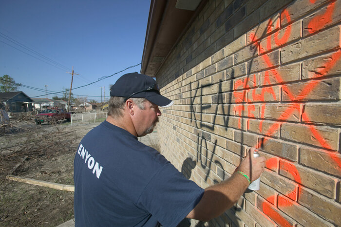 FEMA News Photo, New Orleans, Louisiana, October 2, 2005. Photograph by Andrea Booher. "Harlow Pickett from Kenyon marks a building with an 'all clear' search and rescue symbol. These were final searches for missing people in the Lower 9th Ward following Hurricane Katrina" (FEMA Caption). FEMA News Photo, New Orleans, Louisiana, October 2, 2005. Photograph by Andrea Booher. "Harlow Pickett from Kenyon marks a building with an 'all clear' search and rescue symbol. These were final searches for missing people in the Lower 9th Ward following Hurricane Katrina" (FEMA Caption).