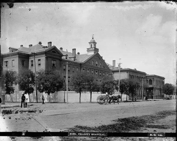 Charity Hospital, New Orleans, Louisiana, ca. 1880–1920. Still image by George François Mugnier. Courtesy of the Louisiana State Museum. A black and white photograph of charity hospital, with a horse drawn carriage and three pedestrians in front. Original text at the bottom of the image reads, "2169. Charity Hospiral. No. 7A."
