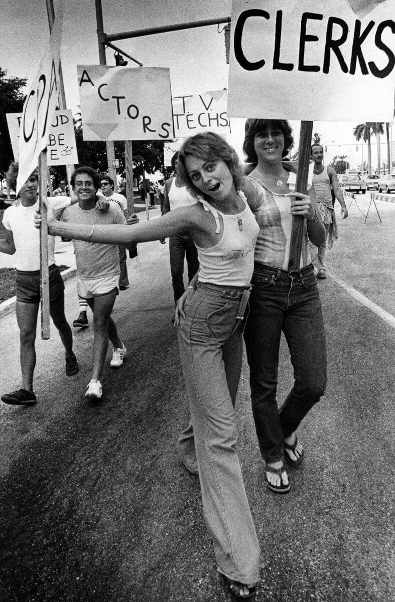 Couples holding signs displaying their professions in Miami's first LGBT parade, Miami, Florida, 1978. Photograph by Tim Chapman. Courtesy of the Tim Chapman Collection, HistoryMiami Museum. Couples holding signs displaying their professions in Miami's first LGBT parade