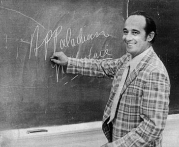 Jim Wayne Miller writes "Appalachian Literature" on a chalkboard, smiling back at the camera.