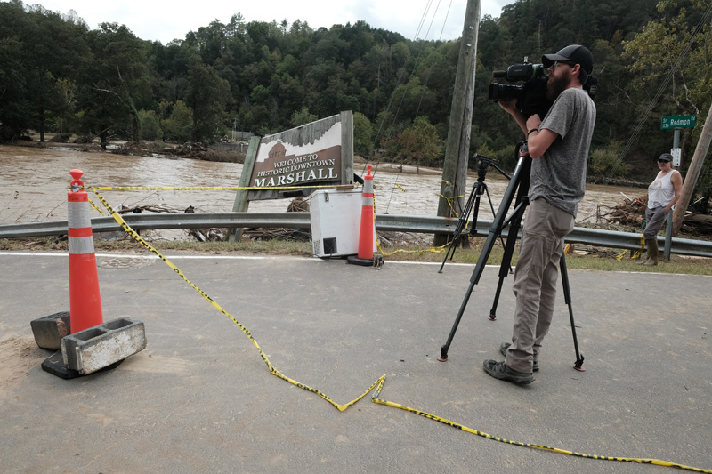 Media videographer filming on Main Street, Marshall, North Carolina, on the day after the flood from Hurricane Helene.