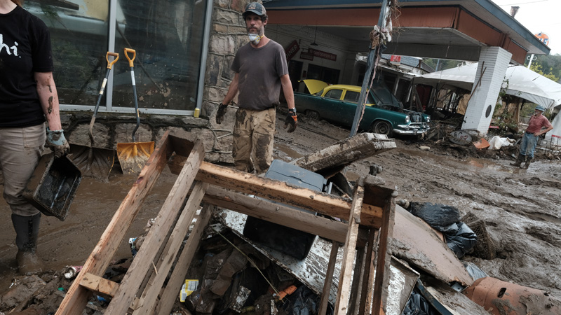 Couple removing debris from used bookstore in Marshall, North Carolina, after Hurricane Helene.