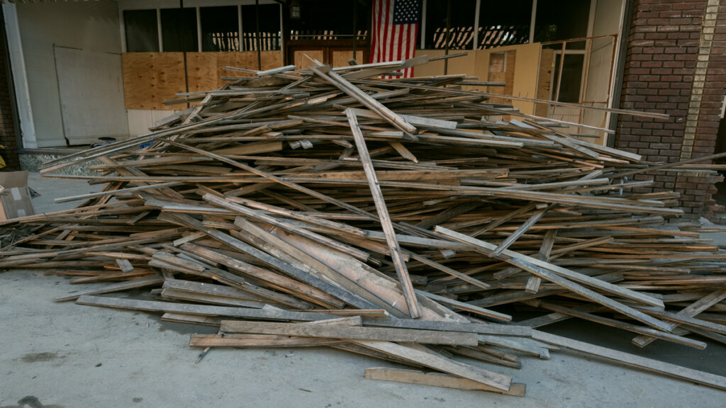 Floor joists in Penlands Department store after flooring has been removed and piled flooring in street. Main street, Marshall, after Hurricane Helene.